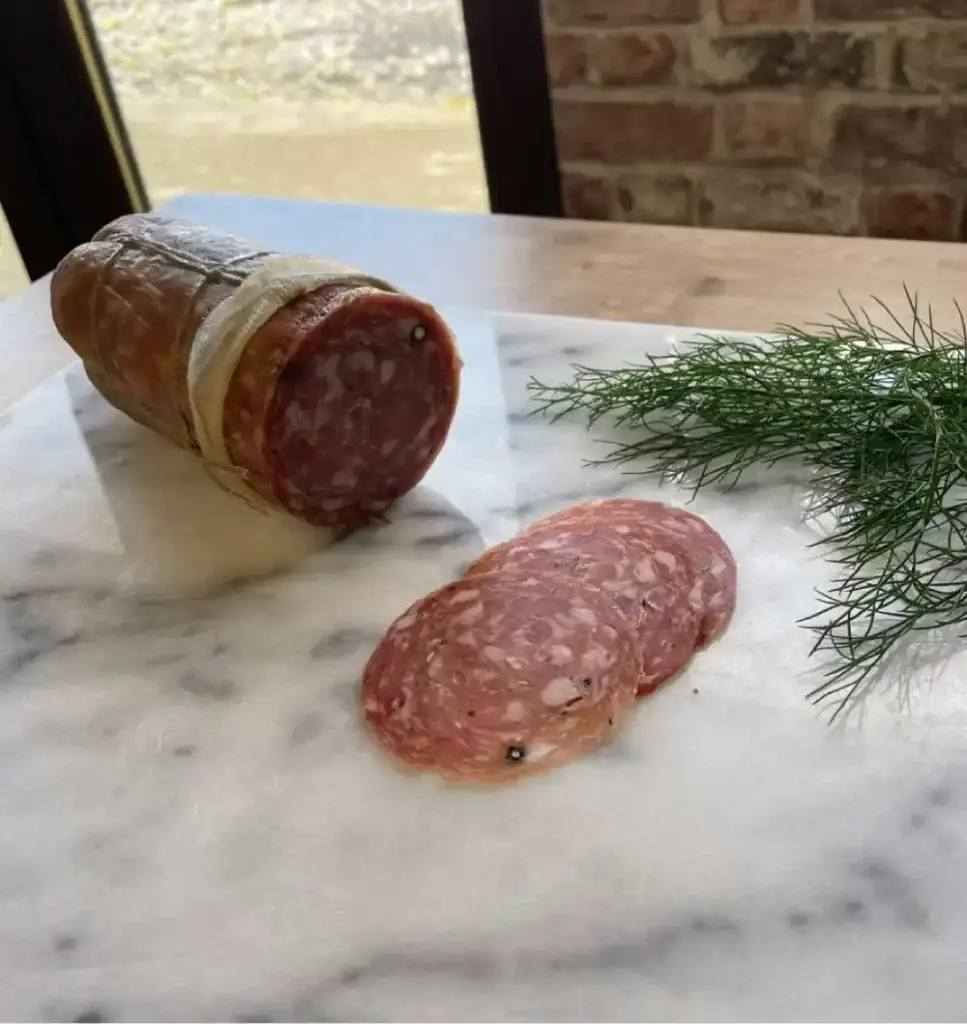 An image of the charcuterie that Farm Gate Farm Shop sells. It shows some salami on a marble chopping board.